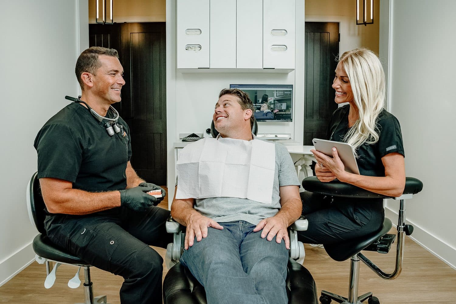 Dentist and hygienist walking a patient through their treatment plan