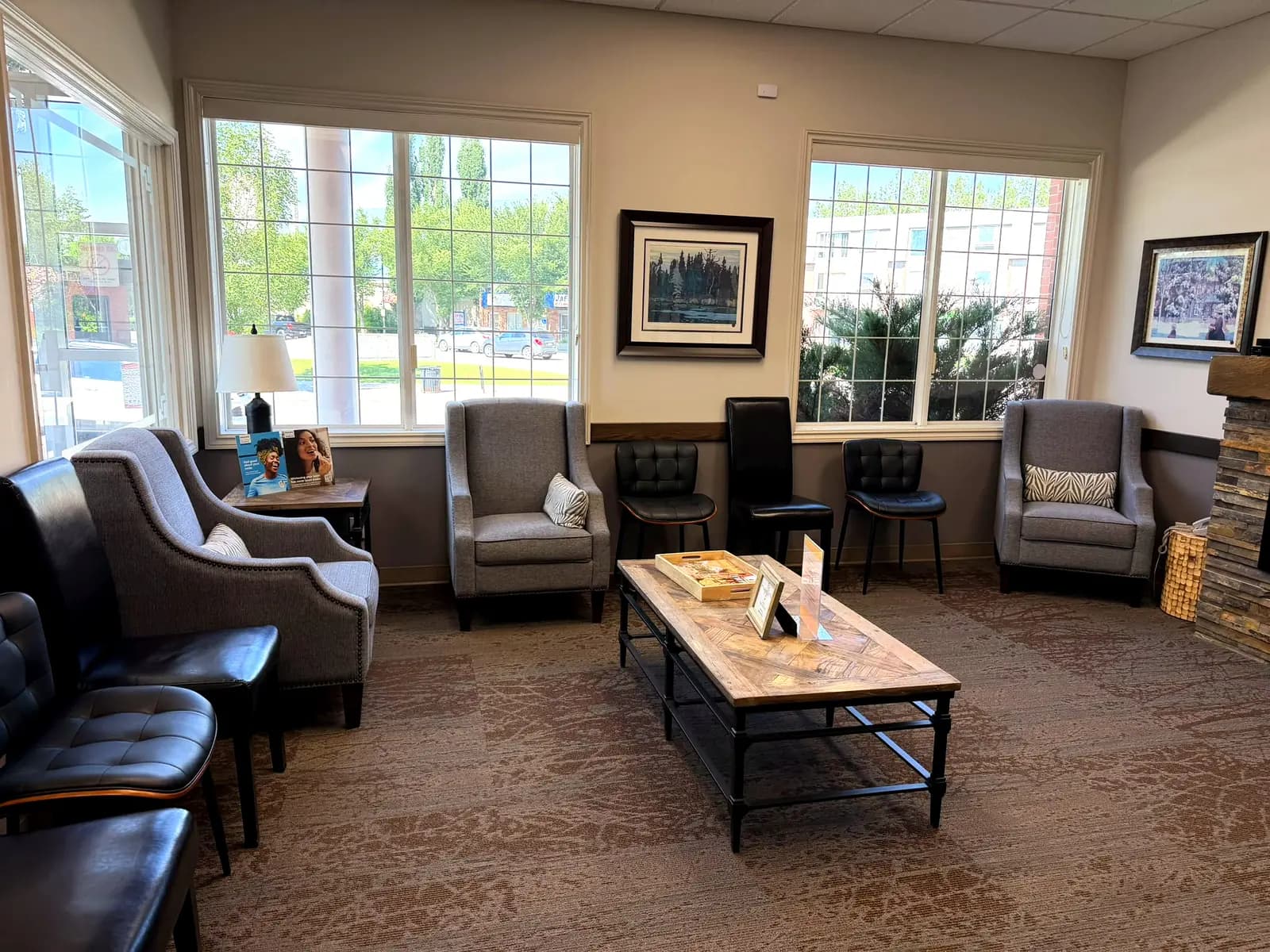 The waiting lounge at High River Dental Centre with armchairs, a fireplace and large windows onto 1 Street SW