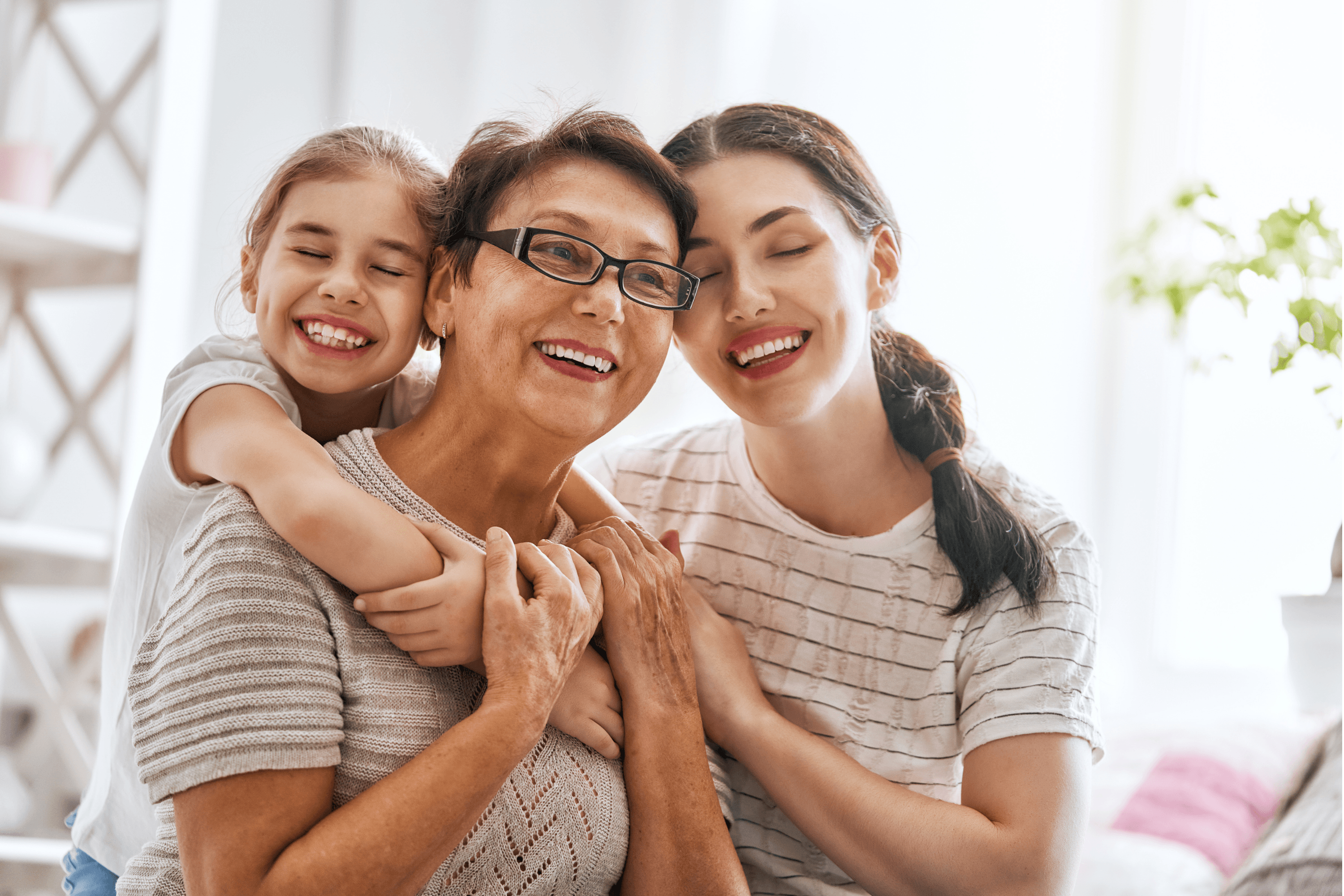 Three generations of women laughing together: grandmother, mother, and daughter