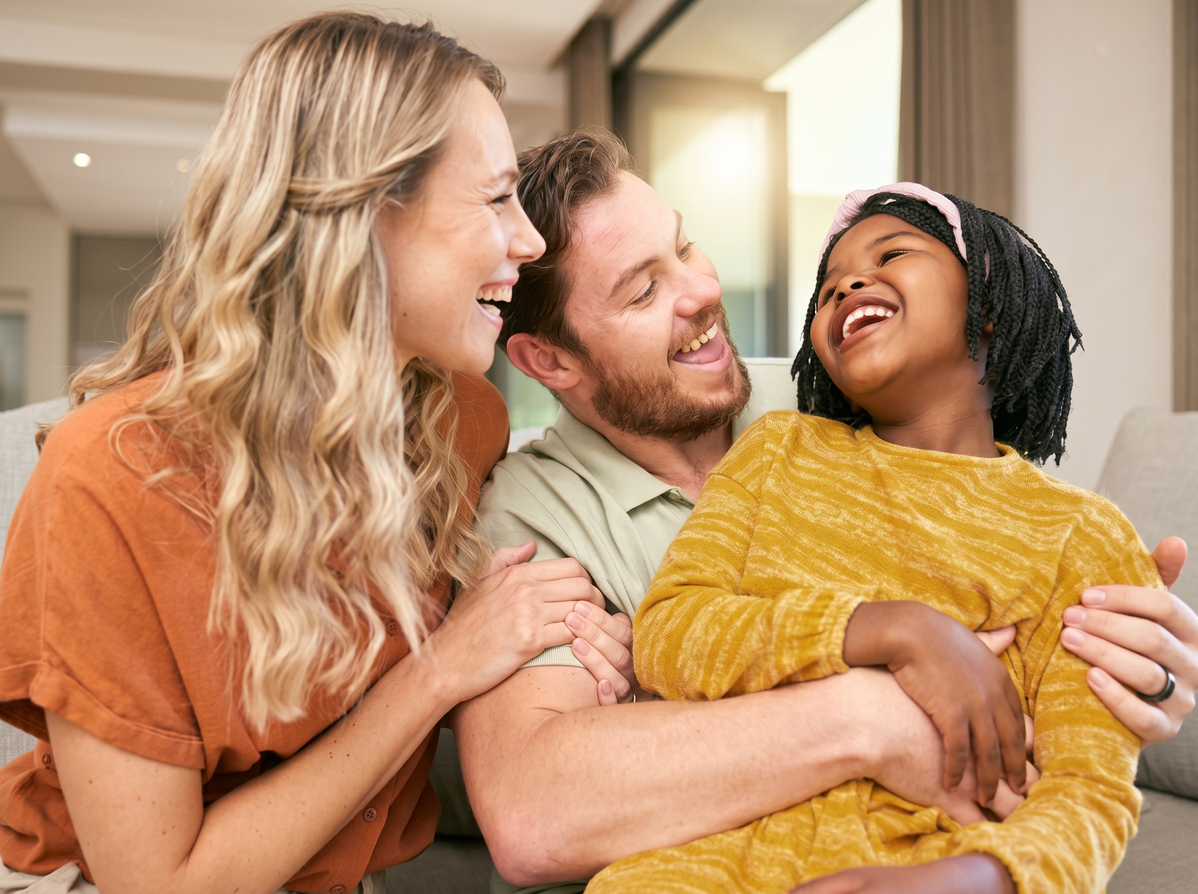 Mixed-race family laughing together on the couch